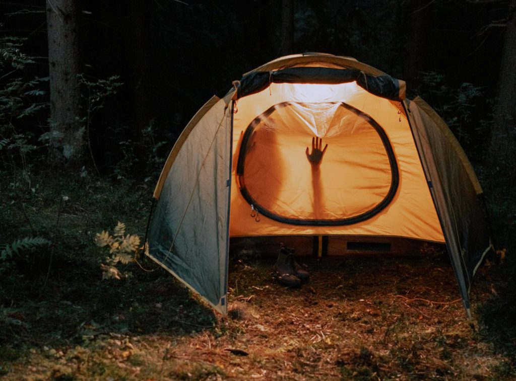 A closed tent with the silhouettes of two people within.